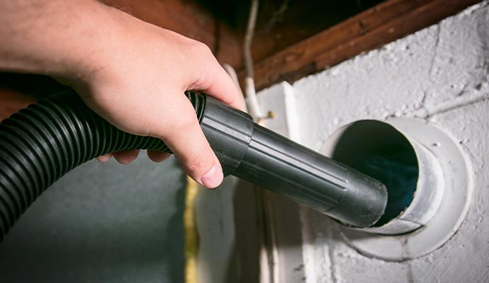 a person using vacuum cleaner for cleaning dryer vent 