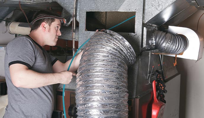 professional worker cleaning air air duct pipe