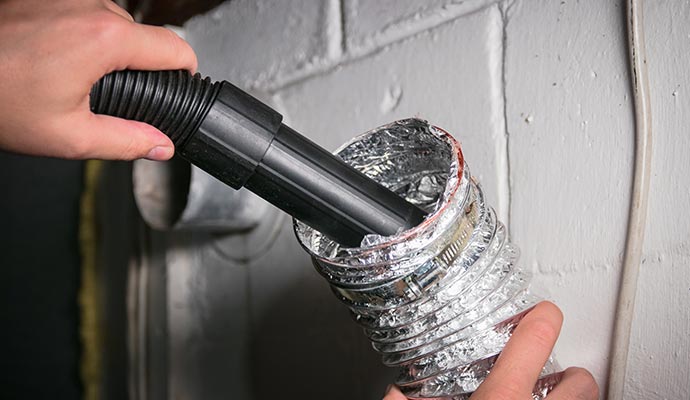 man vacuuming duct pipe
