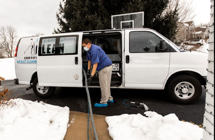 A team member working beside of Hydro-Clean service van